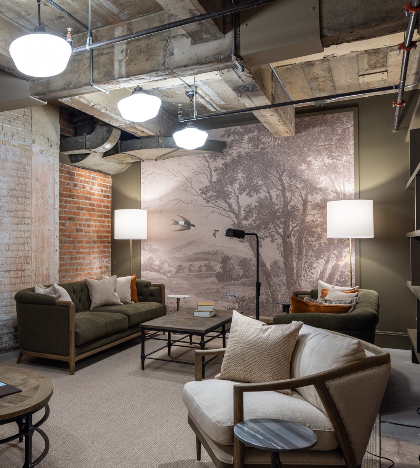 View of lobby lounge back wall with brick wall, couches, and floor lamps