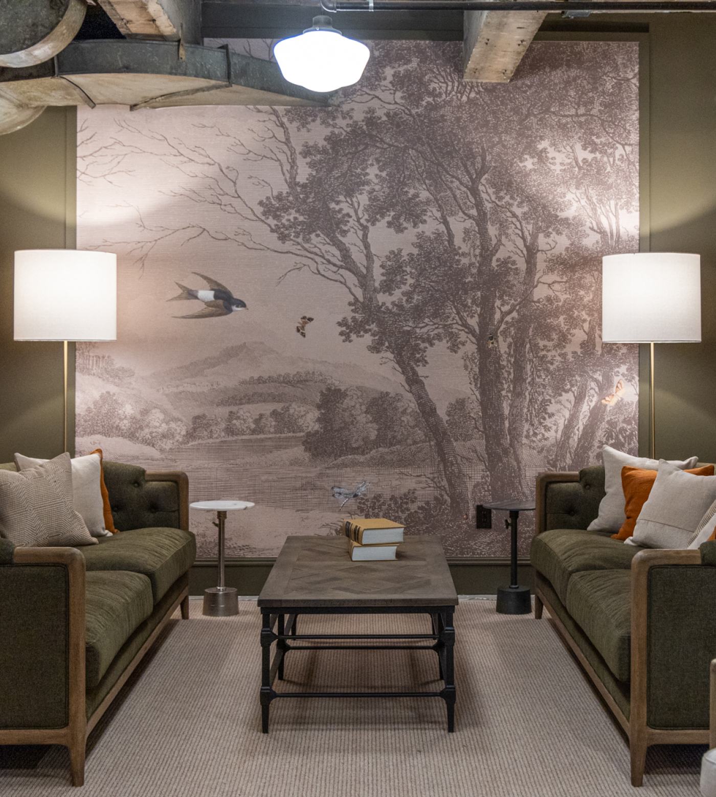 View of lobby lounge back wall with large piece of art depicting a duck flying over a pond with trees
