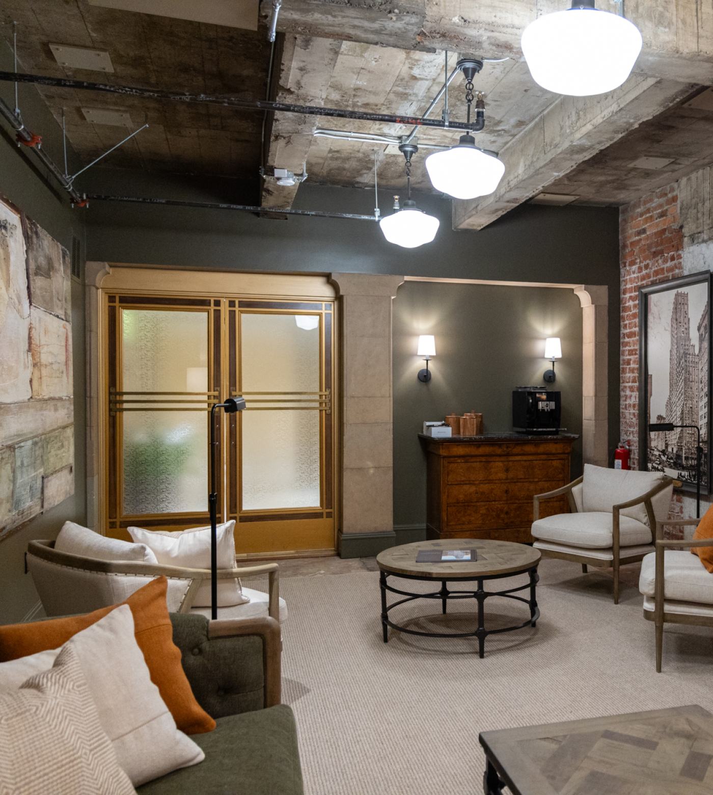 View of front lobby lounge with art deco doors, coffee nook, and mid-century modern furniture.